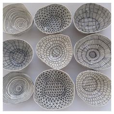 nine white bowls with black lines on them