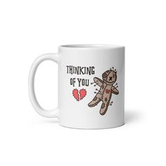 a white coffee mug with the words thinking of you and a teddy bear on it