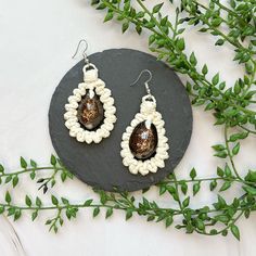 All Speck products were made by REAL Pacific Island women with REAL native Pacific Island materials. ITEM DESCRIPTION: These bold teardrop earrings feature fine strands of naiu (young coconut leaf) with a jumbo dark money cowrie shell centerpiece. Earrings measure 1.5" tall and 1.25" wide. ABOUT SPECK: Speck was created to help Pacific Island natives share the genuine beauty and culture of their islands. All Speck products were designed and created by Pacific Island natives. Every necklace, brac Handmade Teardrop Earrings For Festival, Teardrop Beaded Earrings For Gift, Pierced Teardrop Beaded Earrings As Gift, Pierced Teardrop Beaded Earrings For Gift, Island Women, Shell Centerpieces, Coconut Leaves, Island Jewelry, Mailing Envelopes