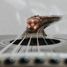 a train traveling down tracks next to a white wall with blue circles around it and an image of a train on the track