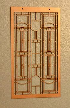 a wooden wall hanging on the side of a wall with an art deco design in it