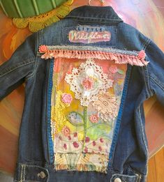 a denim jacket with lace and flowers on it