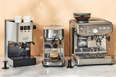 two espresso machines sitting next to each other on a counter