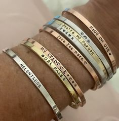 a woman's arm with four different bracelets on it