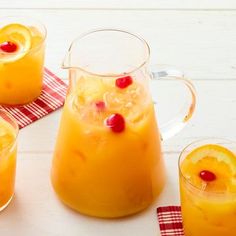 three glasses filled with orange juice and garnished with pomegranates