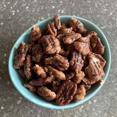 a blue bowl filled with nuts on top of a table