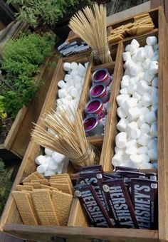 marshmallows and other items are arranged in a wooden box on the ground