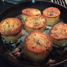 some food is being cooked in a pan on the stove top with oil and seasoning