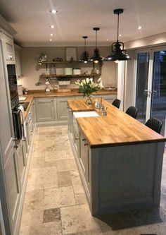 a large kitchen with an island and wooden counter tops