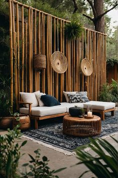 a living room with lots of plants and furniture in front of a bamboo screen wall