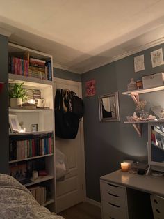 a bedroom with a bed, desk and bookshelf full of books in it