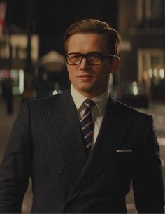 a man in a suit and tie standing on the street