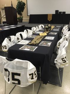 the tables are covered with black and white cloths for sports themed event decorating