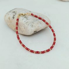 "This delicate berry red and gold bracelet has been lovingly made using 3mm glass Miyuki seed beads. Highlighted with 2mm gold Miyuki seed beads.  The vibrant colours are simply stunning and take your thoughts Christmas. Perfect as a gift or a treat for yourself. Threaded on strong stainless steel 7 strand Tiger Tail wire and finished with gold plated wire guardians, and a trigger clasp and optional extender chain. More Colours and Designs can be found at: https://www.etsy.com/uk/shop/CraftHutCo Red Beaded Dainty Jewelry, Red Dainty Jewelry With Round Beads, Dainty Red Round Bead Jewelry, Red Dainty Round Beaded Jewelry, Dainty Red Round Beaded Jewelry, Red Beaded Friendship Bracelets, Red Crystal Bracelet With Spacer Beads, Dainty Red Beaded Bracelets With Tiny Beads, Hand-strung Red Friendship Bracelets With Round Beads