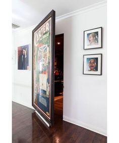 an open door leading into a room with pictures on the wall and wood flooring