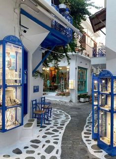 an alley way with blue and white furniture on the sides, in front of a building