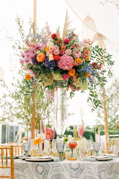 a vase filled with flowers sitting on top of a table covered in plates and napkins