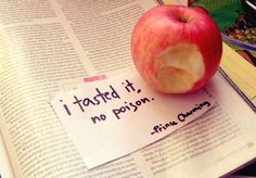 an apple sitting on top of a newspaper with a piece of paper taped to it