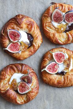 four pastries with figs and cream on them