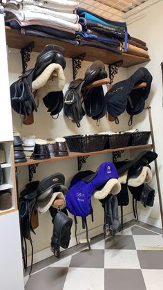 several pairs of horse riding boots are lined up on a shelf in a room with checkered flooring