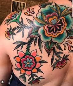 the back of a woman's shoulder with flowers and leaves painted on her chest