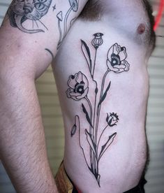 a man with tattoos on his stomach has flowers tattooed on his chest and behind his back