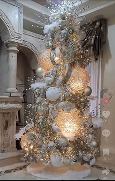 a white christmas tree with gold and silver ornaments