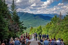 a couple getting married at the end of their wedding ceremony on top of a mountain