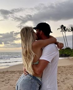 a man and woman embracing on the beach