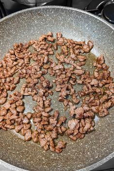 some meat is cooking in a pan on the stove