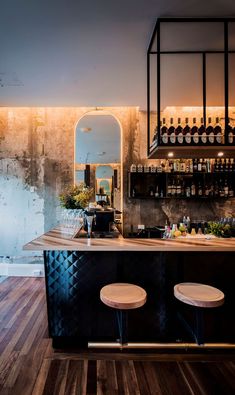 a bar with stools and bottles on it