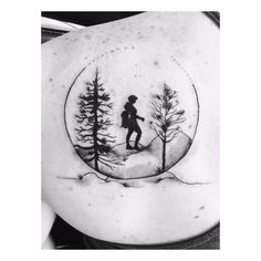 a woman's back with trees and a boy on it