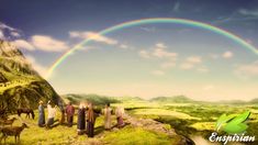 a group of people standing on top of a lush green hillside under a rainbow filled sky