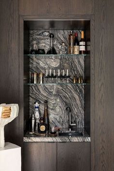 a marble shelf filled with bottles and glasses