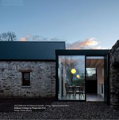 the house is made out of stone and has sliding glass doors that open to let in light