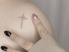 a woman with black and white nails has a star tattoo on her left side shoulder