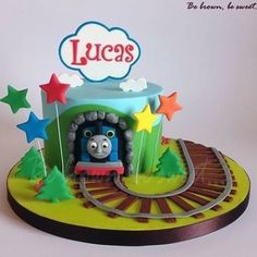 a thomas the train birthday cake with stars around it and a name that says lucas on top