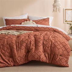 a bed with an orange comforter and pillows