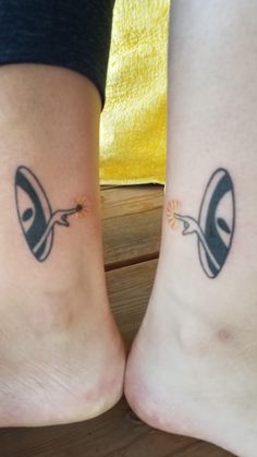 two people with matching tattoos on their feet, one has an eye and the other has a nose