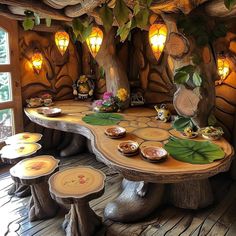 a wooden table topped with lots of plates and bowls next to a forest like wall