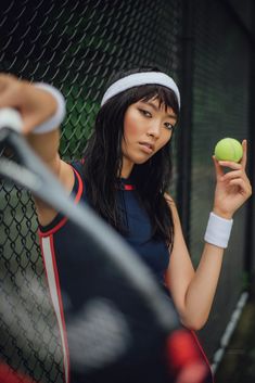 a woman holding a tennis ball and racket