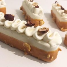 several pieces of cake with white frosting and nuts on top