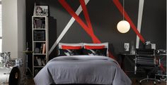 a bedroom decorated in black, white and red with an abstract wall mural behind the bed