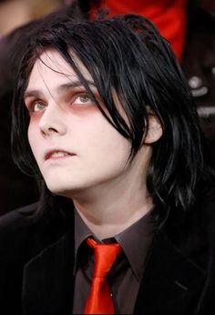 a man with black hair wearing a red tie