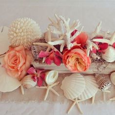 seashells and flowers are arranged on a table