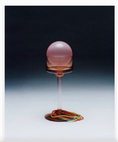 a wine glass with a pink ball on top and some wires in the bottom that are connected to it