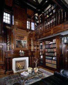 a living room filled with lots of wooden furniture and bookshelves next to a fire place