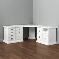 a white corner desk with drawers in an empty room