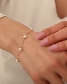 Das "Precious Pearls Armband" besticht durch seine einzigartige Gestaltung, bei der echte Süßwasserperlen kunstvoll entlang einer zarten Kugelkette platziert sind. Diese Perlen verleihen dem Armband eine natürliche Schönheit und einen besonderen Glanz, der alle Blicke auf sich zieht. Jede Perle ist sorgfältig ausgewählt und verleiht dem Armband eine unverwechselbare Note. 14k Gold Filled Bracelet With Pearl Chain As Gift, 14k Gold Filled Pearl Chain Bracelet Gift, Yellow Gold Chain Bracelet With Pearl Charm, Yellow Gold Pearl Chain Bracelet With Pearl Charm, Pearl White Bracelets With Pearl Pendant For Weddings, Elegant Rose Gold Pearl Bracelet With Jubilee Detail, Elegant Rose Gold Pearl Bracelet With Jubilee Style, Elegant Bracelet With Pearl Pendant As Gift, Elegant Bracelets With Pearl Pendant As Gift