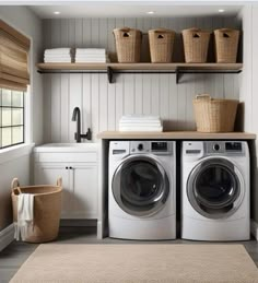 a washer and dryer in a laundry room with shelves above them, along with baskets on the wall